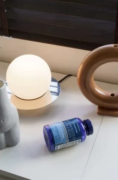 年輕美麗的女性使用營養補充品進行抗老保養